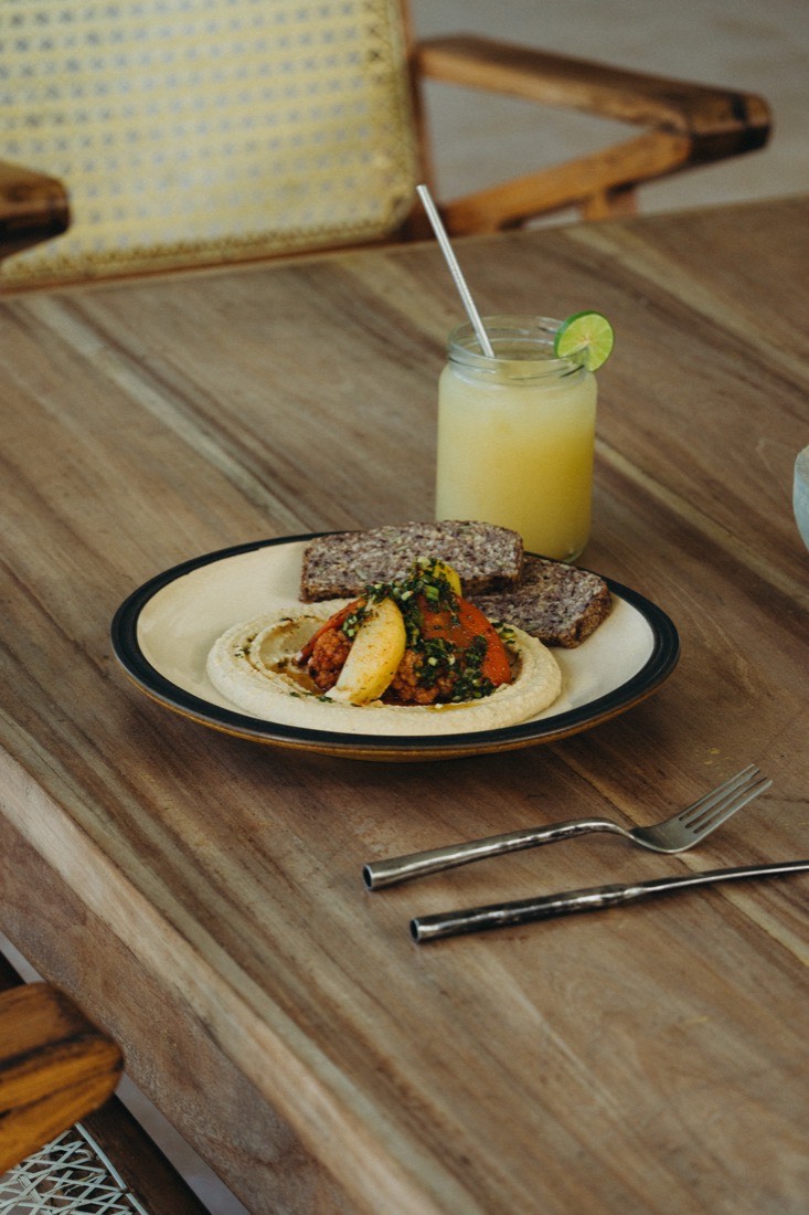 A plated vegan meal with hummus, roasted vegetables and a fresh lime drink at Lanka Yoga